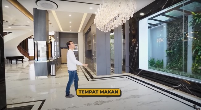 Di sebelah dapur kering terdapat ruang makan yang juga dihiasi dengan lampu gantung. Sayangnya meja makan yang sudah dipesan dokter Richard belum datang. Dengan dinding kaca di beberapa sisinya, ruang makan tersebut menyuguhkan pemandangan pepohonan hijau dan halaman belakang rumah dokter Richard Lee. Foto: YouTube/dr. Richard Lee, MARS