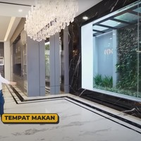 Di sebelah dapur kering terdapat ruang makan yang juga dihiasi dengan lampu gantung. Sayangnya meja makan yang sudah dipesan dokter Richard belum datang. Dengan dinding kaca di beberapa sisinya, ruang makan tersebut menyuguhkan pemandangan pepohonan hijau dan halaman belakang rumah dokter Richard Lee. Foto: YouTube/dr. Richard Lee, MARS