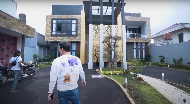 Melalui akun YouTube pribadinya dokter Richard Lee membagikan potret rumah baru yang disebutnya seharga Rp 70 miliar. Dari depan rumah tersebut tampak didominasi warna hitam dan gold dengan halaman yang cukup luas. Di halaman rumahnya itu juga terdapat tanaman yang harganya mencapai Rp 33 juta. Foto: YouTube/dr. Richard Lee, MARS