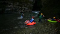 Wisatawan asyik berenang atau sekadar bersantai dengan mengapung di atas ban renang, sambil menikmati suasana di Ngarai Guape yang menakjubkan.  