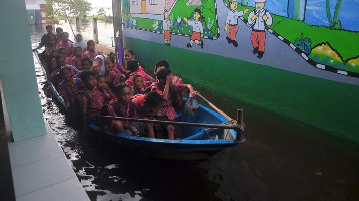 Siswa pulang membonceng sepeda dengan kakeknya usai mengikuti Ujian Tengah Semester (UTS) di SD N 4 Karangrowo yang tergenang banjir di Desa Karangrowo, Undaan, Kudus, Jawa Tengah, Rabu (1/3/2023). Sebanyak 158 siswa terpaksa melaksanakan UTS di Mushola dan sebagian lainnya di Sekolah dengan halaman yang tergenang akibat banjir yang melanda wilayah itu sejak sepekan terakhir. ANTARA FOTO/Yusuf Nugroho/aww.