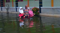 Siswa pulang membonceng sepeda dengan kakeknya usai mengikuti Ujian Tengah Semester (UTS) di SD N 4 Karangrowo yang tergenang banjir di Desa Karangrowo, Undaan, Kudus, Jawa Tengah, Rabu (1/3/2023).