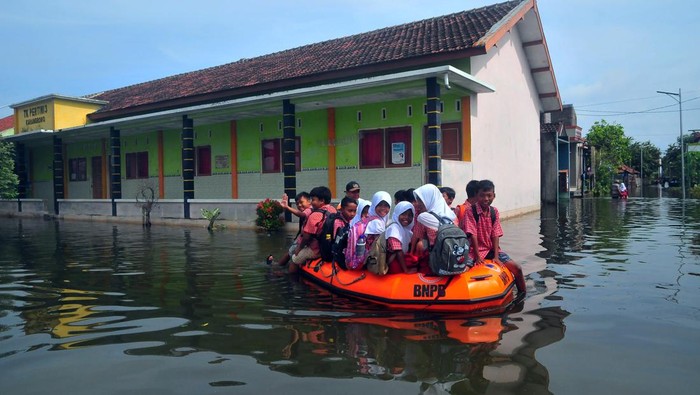 Siswa pulang membonceng sepeda dengan kakeknya usai mengikuti Ujian Tengah Semester (UTS) di SD N 4 Karangrowo yang tergenang banjir di Desa Karangrowo, Undaan, Kudus, Jawa Tengah, Rabu (1/3/2023). Sebanyak 158 siswa terpaksa melaksanakan UTS di Mushola dan sebagian lainnya di Sekolah dengan halaman yang tergenang akibat banjir yang melanda wilayah itu sejak sepekan terakhir. ANTARA FOTO/Yusuf Nugroho/aww.