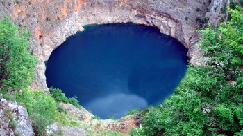 Fenomena karst Crveno Jezero terkenal dengan ukurannya yang besar dan karakteristiknya yang khas di seluruh dunia. Beberapa pengukuran hidrologi di permukaan danau dilakukan pada tahun 1950-an, termasuk pembacaan kedalaman di 39 lokasi. Dengan 18 cekungan besar atau kecil yang kering atau berisi air, Crveno Jezero Red Lake, yang letaknya kurang dari satu kilometer di sebelah barat Imotski, adalah yang terbesar di area tersebut baik dari segi luas area yang terlihat maupun yang tidak terlihat. Namanya mengacu pada bebatuan merah yang bertengger di tebing yang menjulang lebih dari 250 meter di atas tanah. Foto: Croatia Review