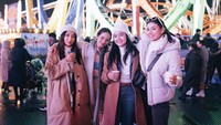 Bersama teman-teman artisnya, Media Dina berpose cantik di taman bermain Winter Wonderland sambil memegang secangkir kopi. Foto: Instagram @medinadinaaa