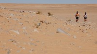 Dua peserta berlari melintasi padang pasir dalam Sahara Marathon edisi XXIII, di Tindouf, Aljazair.  
