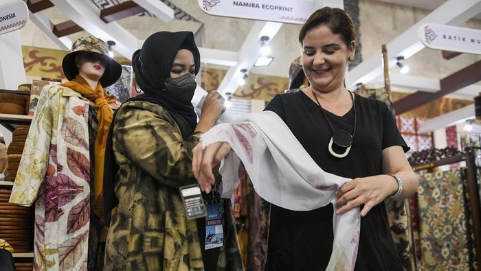 Pengunjung warga negara asing mencoba produk kerajinan kain ecoprint pada pameran The Jakarta International Handicraft Trade Fair (INACRAFT) 2023 di Jakarta Convention Center,  Jakarta, Rabu (1/3/2023). Pameran produk kerajinan terbesar di Asia Tenggara itu diikuti 1118 UKM yang digelar pada 1-5 Maret 2023. ANTARA FOTO/Hafidz Mubarak A/aww.