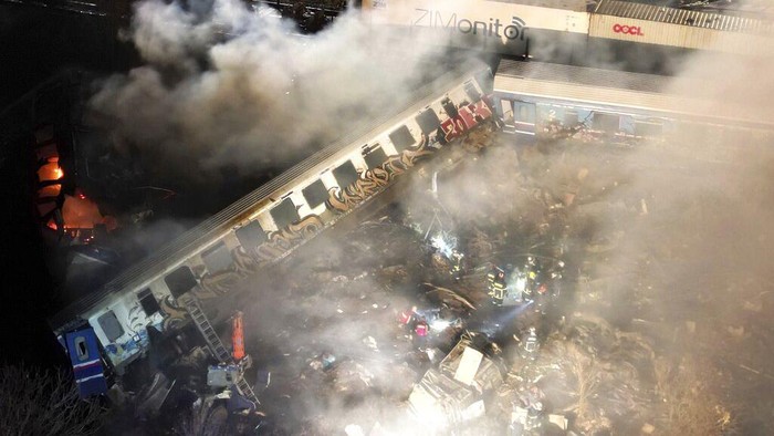 Smoke rises from trains as firefighters and rescuers operate after a collision near Larissa city, Greece, early Wednesday, March 1, 2023. The collision between a freight and passenger train occurred near Tempe, some 380 kilometers (235 miles) north of Athens, and resulted in the derailment of several train cars. (AP Photo/Vaggelis Kousioras)