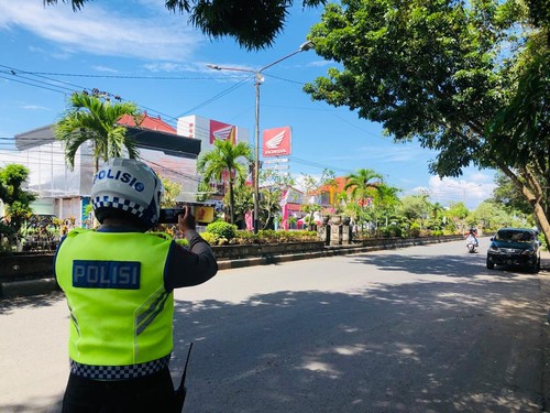 Petugas Satlantas Polres Jembrana saat memotret pelanggar lalulintas di wilayah kota Negara, Rabu (1/3/2023).
