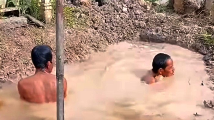 Warga di Hulu Sungai Selatan mengebumikan jenazah di liang lahad penuh air.