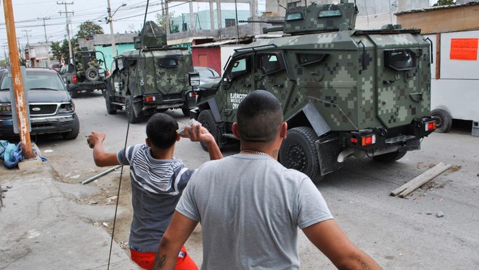 People beat a soldier near the area where, according to local media, five people were shot dead by Mexican soldiers, in Nuevo Laredo, Mexico February 26, 2023. REUTERS/Jasiel Rubio NO RESALES. NO ARCHIVES