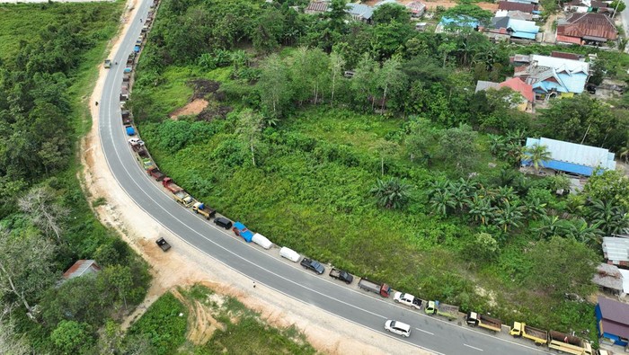 Foto udara antrean truk yang akan mengisi BBM jenis solar bersubdisi di sekitar SPBU 749301, di perbatasan antara Kabupaten Konawe Selatan dan Kota Kendari, Sulawesi Tenggara, Kamis (2/3/2023). Para sopir truk harus harus menunggu selama dua hari untuk mendapatkan 60 liter solar bersubdisi. ANTARA FOTO/Jojon/tom.