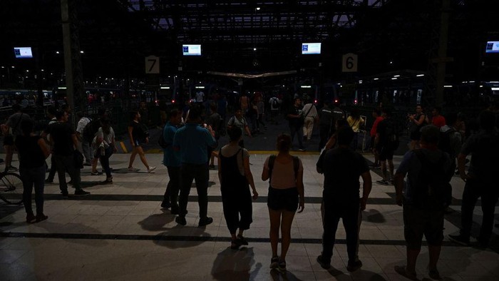 Argentina Gelap Gulita Gegara Kebakaran Saluran Listrik Tegangan Tinggi Commuters wait at the Constitucion train station in Buenos Aires on March 1st, 2023, following an outage caused by a fire which affected the high-voltage system. - A massive power outage caused by a fire -in a field 60km north of Buenos Aires and near the high-voltage power lines that connect to the Atucha 1 nuclear power plant- affected millions of people in part of Buenos Aires and several provinces for at least two hours, authorities stated. (Photo by Luis ROBAYO / AFP) (Photo by LUIS ROBAYO/AFP via Getty Images)