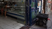 Seorang wanita membeli barang di supermarket yang diterangi generator listrik, di Buenos Aires, menyusul pemadaman listrik akibat kebakaran yang memengaruhi sistem tegangan tinggi. Di ibu kota, lampu berkedip kembali sekitar pukul 18:00 (2100 GMT) di sistem metro, dan layanan publik secara bertahap dipulihkan. Luis Robayo/AFP/Getty Images