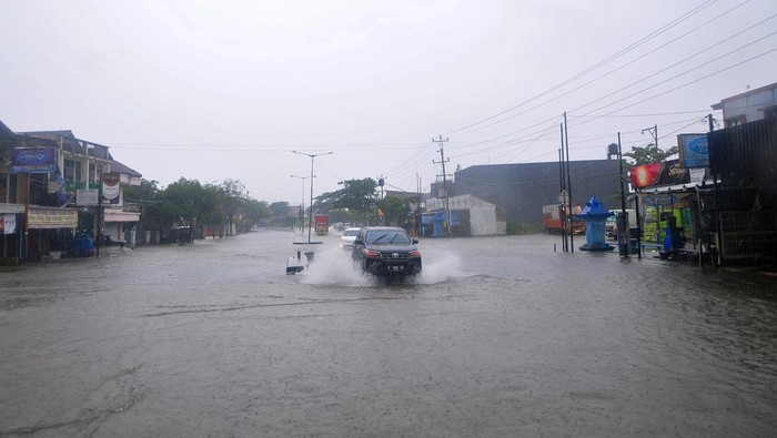 Sejumlah kendaraan menerobos jalan yang tergenang banjir di jalur Pantura, Desa Jati Wetan, Kudus, Jawa Tengah, Kamis (2/3/2023). Banjir akibat curah hujan tinggi dengan ketinggian mencapai 30 centimeter itu menyebabkan kemacetan dari arah Kudus menuju Semarang. ANTARA FOTO/Yusuf Nugroho/tom.