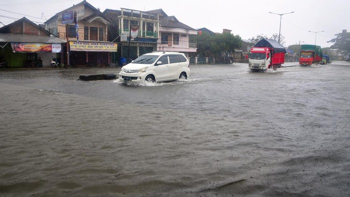 Sejumlah kendaraan menerobos jalan yang tergenang banjir di jalur Pantura, Desa Jati Wetan, Kudus, Jawa Tengah, Kamis (2/3/2023). Banjir akibat curah hujan tinggi dengan ketinggian mencapai 30 centimeter itu menyebabkan kemacetan dari arah Kudus menuju Semarang. ANTARA FOTO/Yusuf Nugroho/tom.