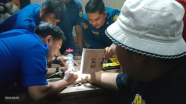 Petugas saat melakukan pelepasan cincin di jari manis Ndarboy Genk yang tidak bisa dilepas selama seminggu.