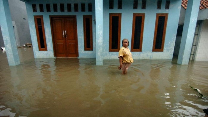 Curah Hujan Tinggi, Ratusan Rumah di Tegal Terendam Banjir Seorang warga duduk di dalam ruangan rumahnya yang tergenang air di Kelurahan Sumurpanggang, Kecamatan Margadana, Tegal, Jawa Tengah, Kamis (2/3/2023). Curah hujan tinggi dan buruknya drainase mengakibatkan ratusan rumah di Kecamatan Margadana terendam banjir.