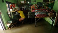 Seorang warga duduk di dalam ruangan rumahnya yang tergenang air di Kelurahan Sumurpanggang, Kecamatan Margadana, Tegal, Jawa Tengah, Kamis (02/03/2023).