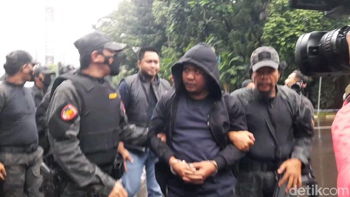 Debt collector si belang biru tiba di Polda Metro usai ditangkap di Labuhanbatu, Sumatera Utara.