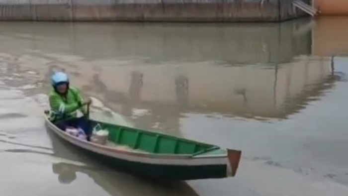 Driver ojol di Wajo, Sulsel pakai perahu antar pesanan warga ke lokasi banjir.