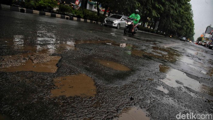 Hujan deras yang terus mengguyur Ibu Kota membuat Jalan Boulevard Raya, Kelapa Gading, Jakarta Utara, kian rusak.