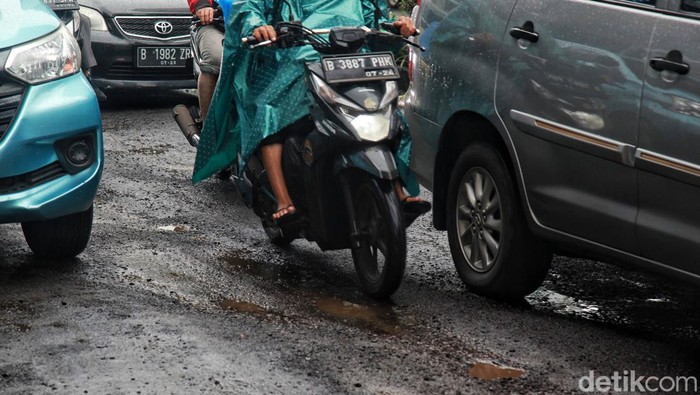 Pengendara yang melintas di Jalan Rasuna Said, Jaksel, harap berhati-hati, Kamis (2/3/2023). Jalan yang membentang di antara gedung pencakar langit itu rusak.