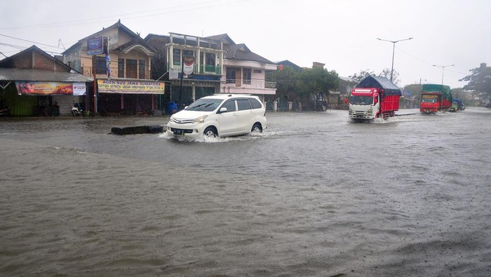 Jalur Pantura Kudus Terendam Banjir Sejumlah kendaraan menerobos jalan yang tergenang banjir di jalur Pantura, Desa Jati Wetan, Kudus, Jawa Tengah, Kamis (2/3/2023). Banjir akibat curah hujan tinggi dengan ketinggian mencapai 30 centimeter itu menyebabkan kemacetan dari arah Kudus menuju Semarang. ANTARA FOTO/Yusuf Nugroho/tom.