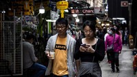 Orang-orang berjalan tanpa memakai masker melalui kawasan pusat bisnis di Hong Kong, saat pemerintah mencabut mandat penggunaan masker, Rabu (1/3/2023). Pemerintah Hong Kong mengumumkan pelonggaran aturan Covid-19 dengan mencabut mandat penggunaan masker pada Rabu, 1 Maret 2023. Kini, warga Hong Kong bebas seperti sebelum pandemi.
