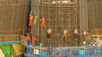 Pekerja mengerjakan konstruksi proyek pembangunan jembatan.  