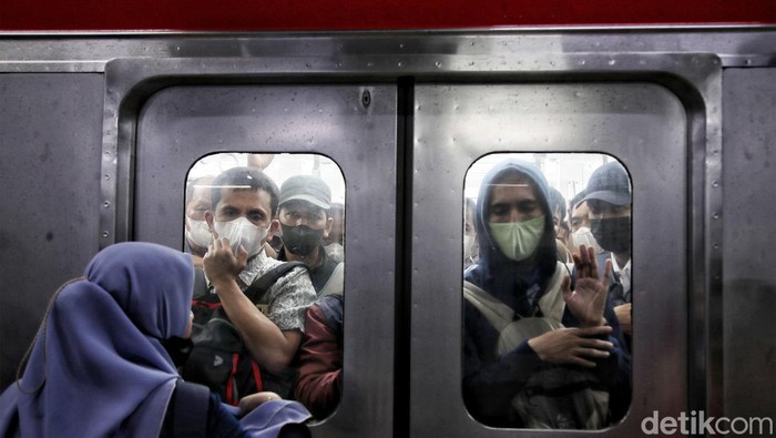 Ratusan penumpang berusaha masuk ke dalam transportasi umum KRL di Stasiun Manggarai, Rabu (22/2/2023).