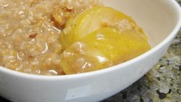 Ide sarapan nih! Oatmeal diberi selai kacang dan irisan apel lalu diaduk rata.