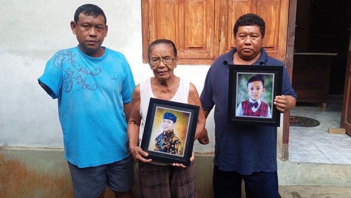 Keluarga korban meninggal dunia saat menunjukan foto dua orang korban akibat kecelakaan maut travel Panca Sari di Banjar Dinas Kelodan, Manggis, Karangasem, Jumat (3/3/2023). (foto: I Wayan Selamat Juniasa)