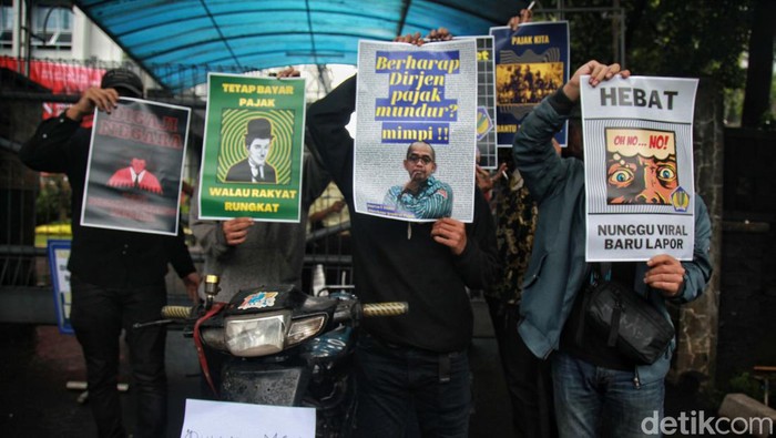 Pendemo Ini Bawa Koin untuk Pejabat Pajak Massa berdemo di Gedung Ditjen Pajak, Jakarta, terkait kasus Rafael Alun. Mereka juga membawa toples bertuliskan sumbangan untuk dirjen pajak.