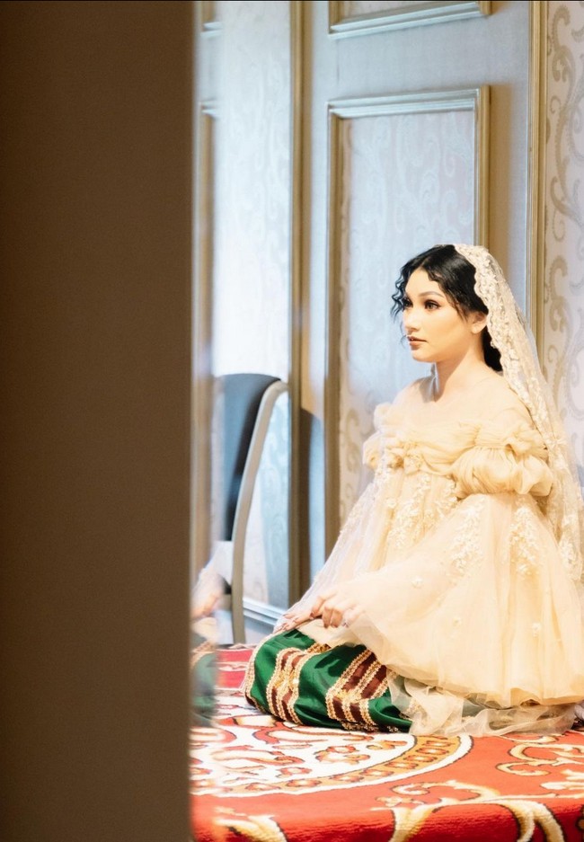 Sinta Mutiara Bella tampil cantik dalam balutan kebaya tunik beraksen ruffle dan lonceng pada bagian bahu serta lengan. Busana atasan dipadukan dengan kain kain tenun khas Bugis. Foto: Instagram/@sintamutiarabell