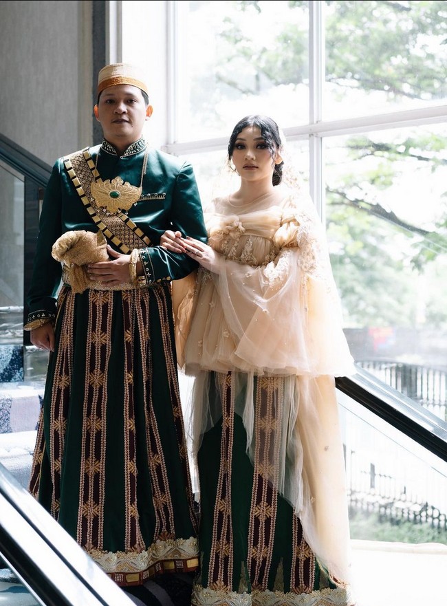 Untuk resepsi, Sinta berganti busana menjadi gaun mewah warna beige dengan hiasan bordir, kristal dan payet. Gaun tersebut juga hasil jahitan Nursyah. Foto: Instagram/@sintamutiarabell