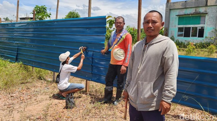 Perwakilan perusahaan yang di duga menyerobot lahan SMKN 9 Batam tengah memasang pagar di tanah sekolah.
