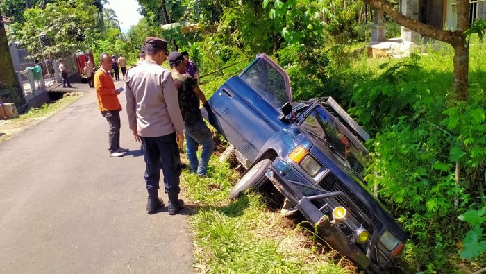 Petugas kepolisian meninjau mobil yang masuk ke parit di Desa Cendana, Kecamatan Kutasari, Kabupaten Purbalingga, Jumat (3/3/2023).