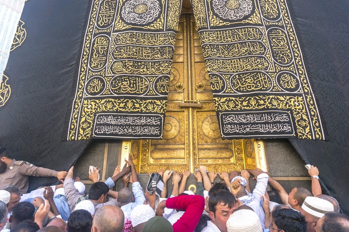 Mecca, Saudi Arabia - March 14, 2015: A close up view of kaaba door and the kiswah (cloth that covers the kaaba) at Masjidil Haram in Makkah, Saudi Arabia. The door is made of pure gold.