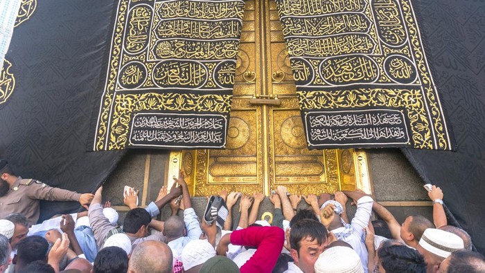 Mecca, Saudi Arabia - March 14, 2015: A close up view of kaaba door and the kiswah (cloth that covers the kaaba) at Masjidil Haram in Makkah, Saudi Arabia. The door is made of pure gold.