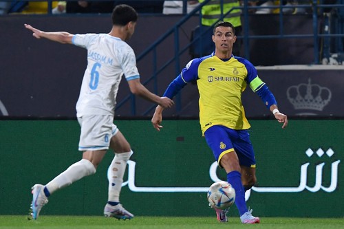 Batins Saudi midfielder Bassam al-Hurayji (L) fights for the ball with Nassrs Portuguese forward Cristiano Ronaldo during the Saudi Pro League football match between Al-Nassr and Al-Batin at the Mrsool Park Stadium in the Saudi capital Riyadh on March 3, 2023. (Photo by AFP) (Photo by -/AFP via Getty Images)