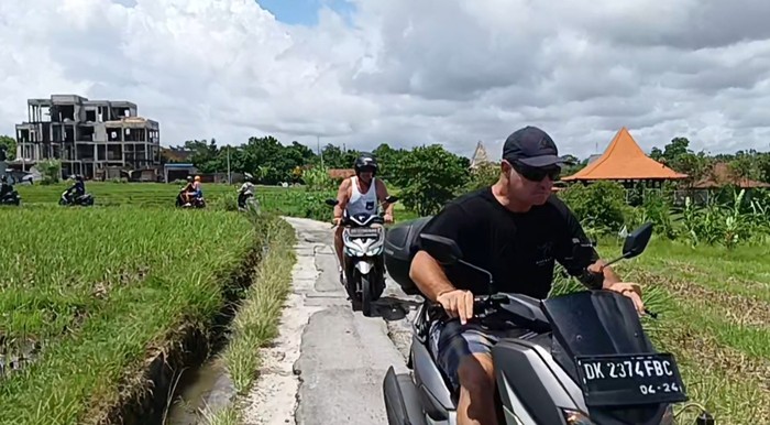 Bule melintas di shortcut Canggu, Badung, Bali.