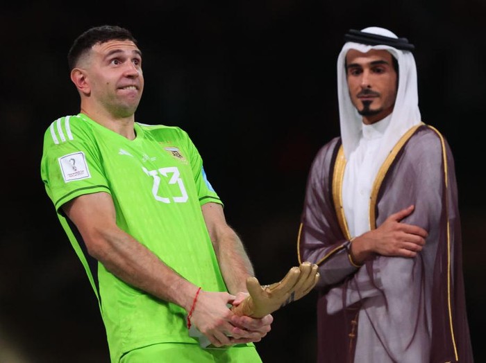 LUSAIL CITY, QATAR - DECEMBER 18: H.E Sheikh Jassim Bin Hamad Al Thani looks on as Emiliano Martinez of Argentina gestures with the world cup trophy during the FIFA World Cup Qatar 2022 Final match between Argentina and France at Lusail Stadium on December 18, 2022 in Lusail City, Qatar. (Photo by Marc Atkins/Getty Images)
