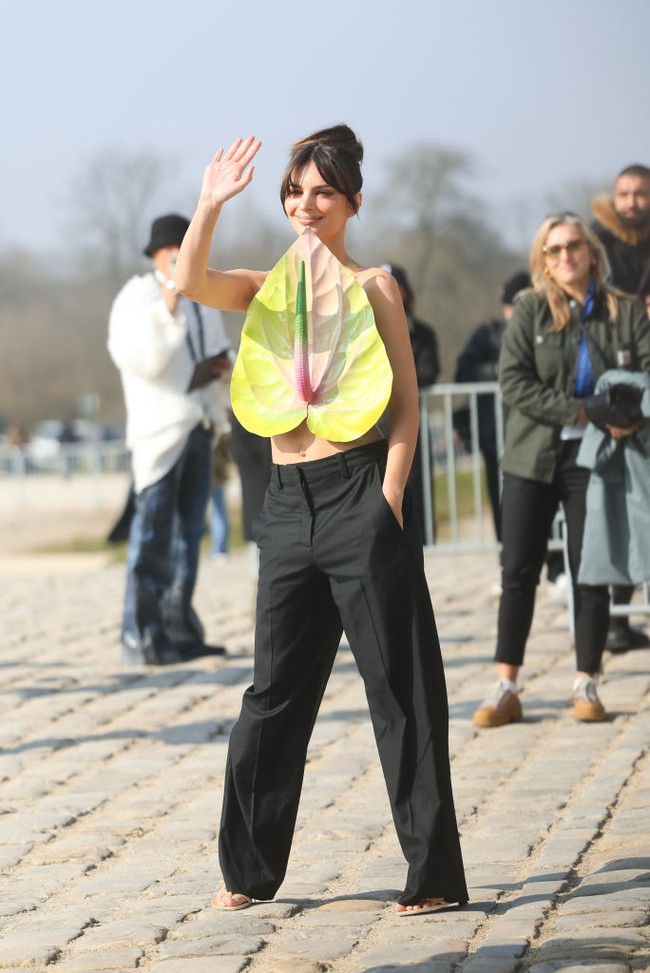 Emily Ratajkowski memadukan baju tiga dimensi itu dengan celana lebar hitam dan strap heels warna beige. Foto: Getty Images/Jacopo Raule