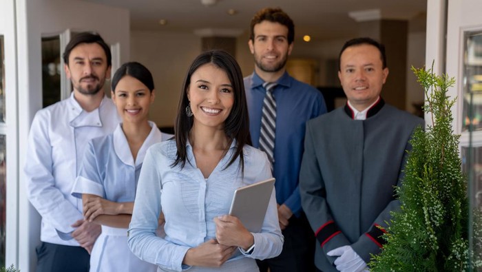 Happy group of Latin American workers at a hotel and looking at the camera smiling