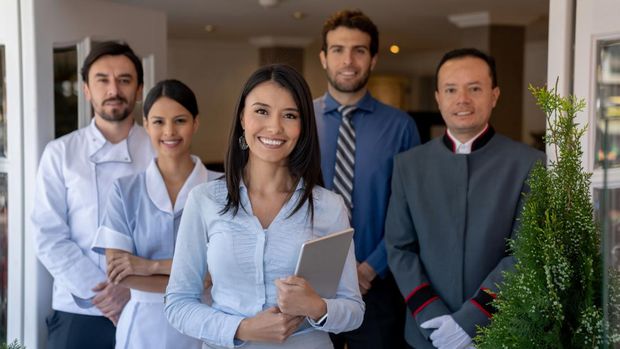 Happy group of Latin American workers at a hotel and looking at the camera smiling