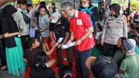 Warga yang mengungsi di RPTRA Rasela, Jakarta Utara, menerima bantuan.