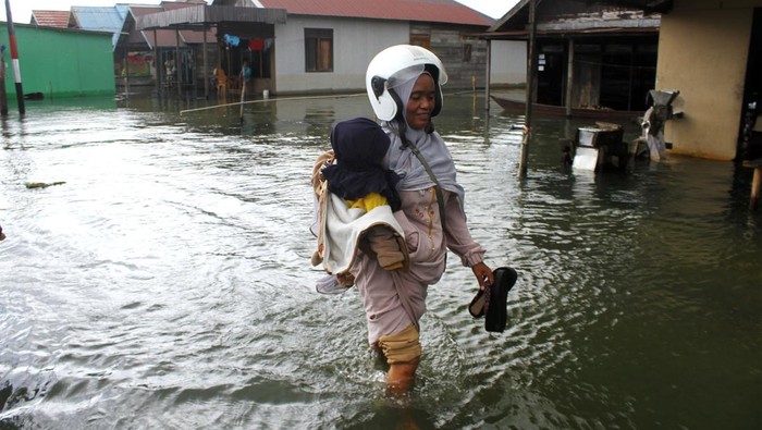 Warga melintasi banjir di Desa Sungai Rangas Ulu, Kabupaten Banjar, Kalimantan Selatan, Sabtu (4/3/2023). Berdasarkan data Badan Pusdalops Badan Nasional Penanggulangan Bencana mencatat sebanyak 1.826 Kepala Keluarga atau 6.440 jiwa terdampak banjir di enam Kecamatan di Kabupaten Banjar. ANTARA FOTO/Bayu Pratama S/foc.