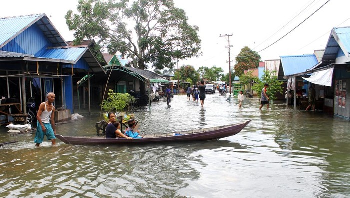 Warga melintasi banjir di Desa Sungai Rangas Ulu, Kabupaten Banjar, Kalimantan Selatan, Sabtu (4/3/2023). Berdasarkan data Badan Pusdalops Badan Nasional Penanggulangan Bencana mencatat sebanyak 1.826 Kepala Keluarga atau 6.440 jiwa terdampak banjir di enam Kecamatan di Kabupaten Banjar. ANTARA FOTO/Bayu Pratama S/foc.