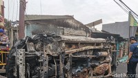 Nampak sebuah mobil dalam posisi miring, dan hangus terbakar.Foto: Ilyas Fadilah/detikcom